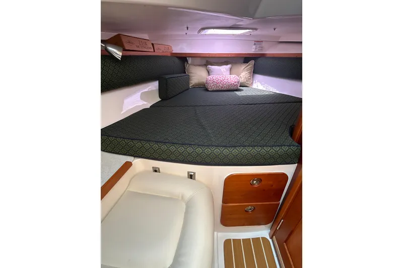 Slide: The Image of 2009 Hunt Yachts Harrier 29 cabin interior with cushioned bed and wooden storage drawers. - 11