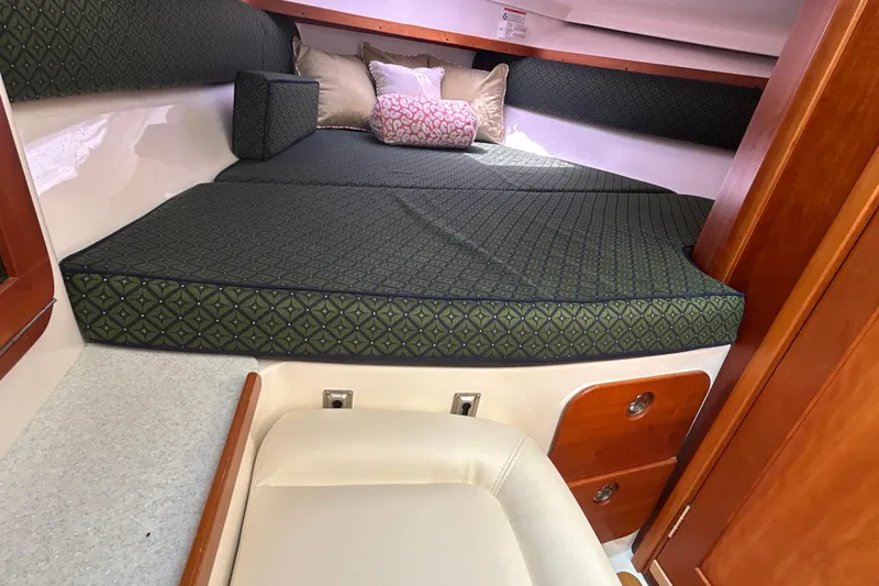 Slide: The Image of 2009 Hunt Yachts Harrier 29 cabin interior with cushioned bed and wooden storage. - 12
