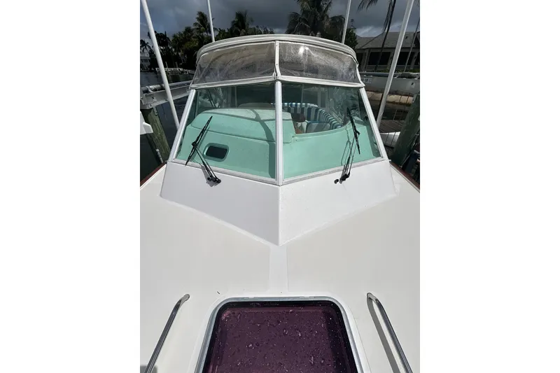 Slide: The Image of 2009 Hunt Yachts Harrier 29 boat with windshield and wipers, docked near palm trees. - 15