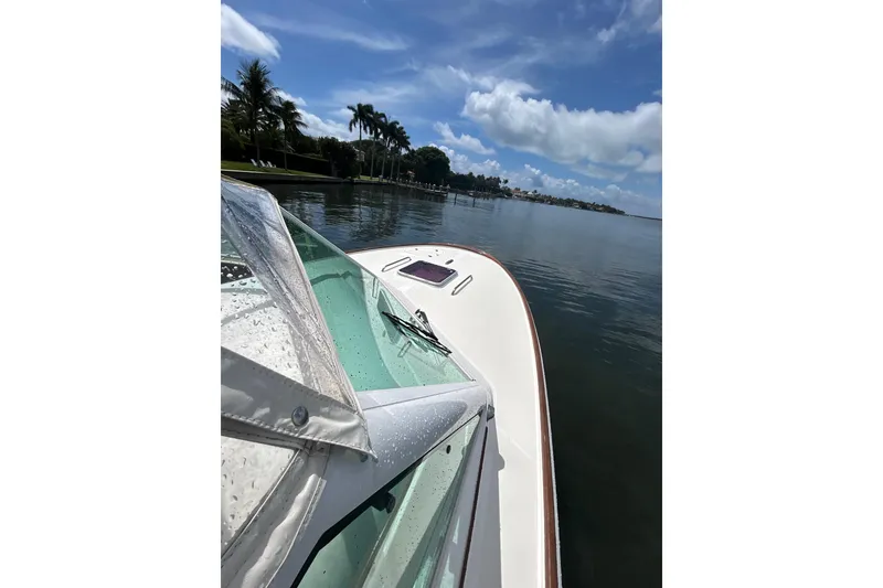 Slide: The Image of 2009 Hunt Yachts Harrier 29 on calm water under a clear blue sky. - 17