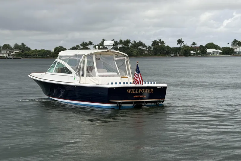 Slide: The Image of 2009 Hunt Yachts Harrier 29 boat on calm water, featuring an American flag. - 3