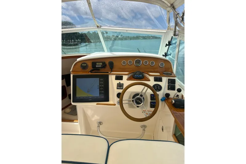 Slide: The Image of 2009 Hunt Yachts Harrier 29 helm with navigation display and classic wooden steering wheel. - 9
