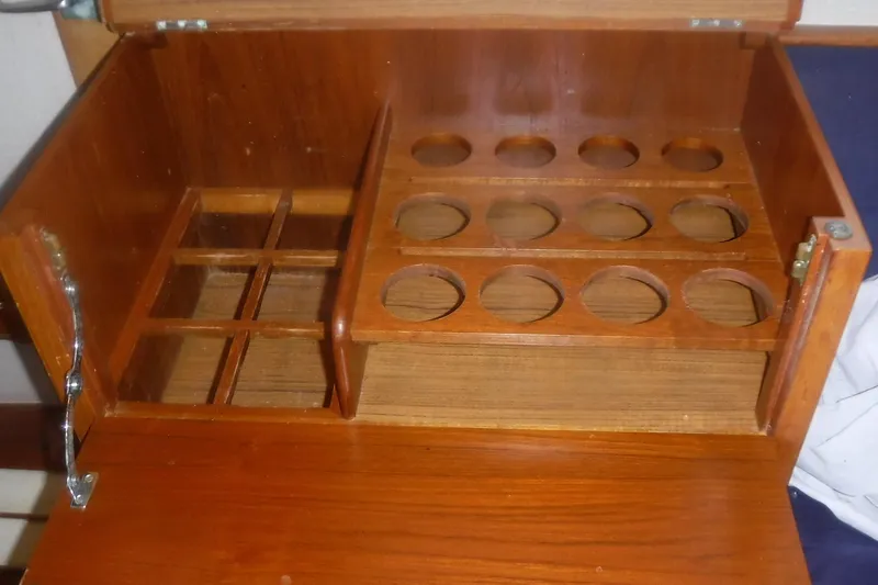 Slide: The Image of Wooden storage compartment on 1983 Grand Banks 36 Classic boat, featuring bottle and glass holders. - 19