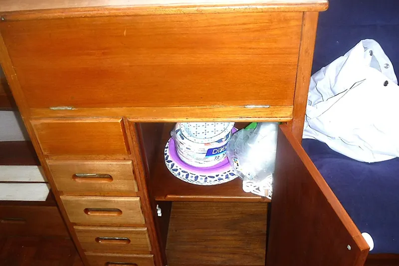 Slide: The Image of Wooden cabinet with open door, revealing storage inside a 1983 Grand Banks 36 Classic. - 20