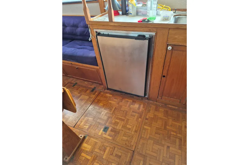 Slide: The Image of 1983 Grand Banks 36 Classic interior with wooden flooring and compact kitchen area. - 22