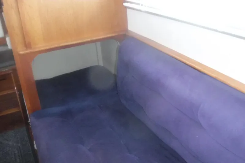 Slide: The Image of Interior seating of 1983 Grand Banks 36 Classic with blue upholstery and wooden accents. - 25
