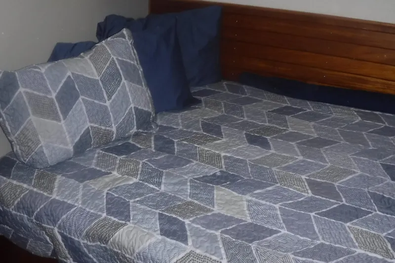 Slide: The Image of Cozy bed with geometric-patterned bedding in a 1983 Grand Banks 36 Classic yacht cabin. - 38