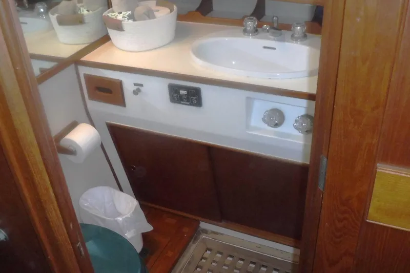 Slide: The Image of 1983 Grand Banks 36 Classic yacht bathroom with sink, wooden cabinetry, and mirror. - 45