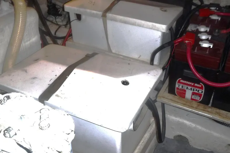 Slide: The Image of Battery compartment of a 1983 Grand Banks 36 Classic boat, featuring multiple batteries and wiring. - 52