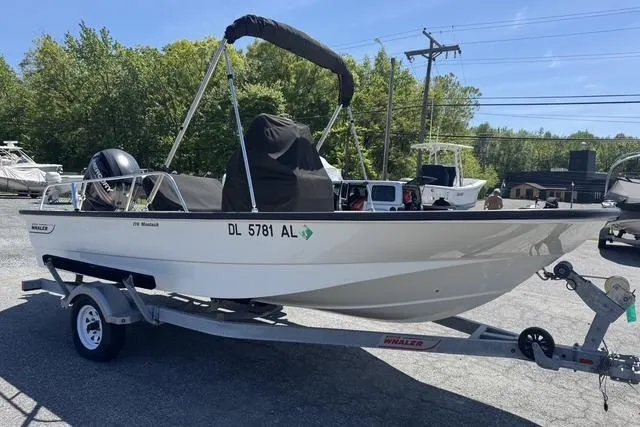 Slide: The Image of 2017 Boston Whaler 170 Montauk boat on trailer in outdoor setting. - 2