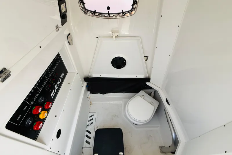 Slide: The Image of 2021 Blackfin 272 CC boat interior with control panel and marine toilet. - 11