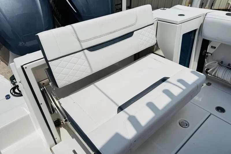 Slide: The Image of 2021 Blackfin 272 CC boat seating area with white cushioned bench and storage. - 14