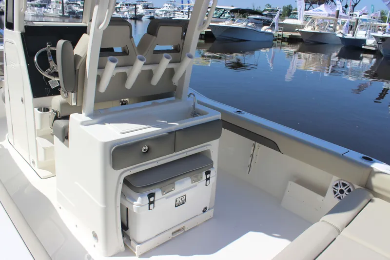 Slide: The Image of 2026 Key West 249 FS boat interior with seating, rod holders, and cooler at marina. - 10