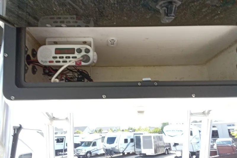 Slide: The Image of Storage compartment with radio equipment in a 2015 Key West 203 FS boat. - 10