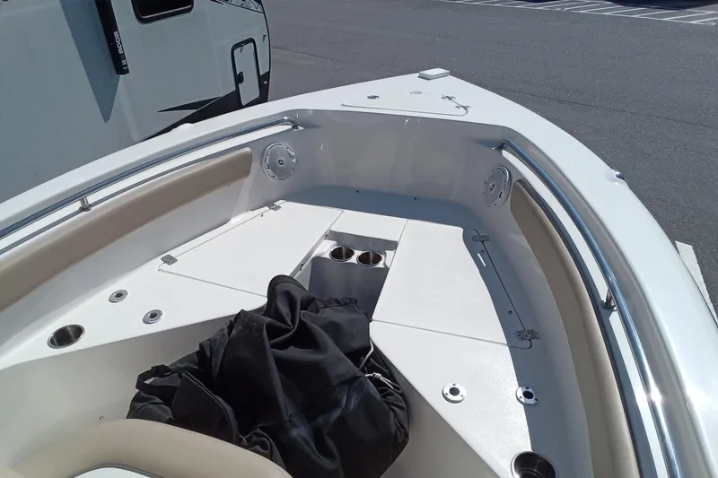 Slide: The Image of Bow seating area of a 2015 Key West 203 FS boat, featuring cup holders and storage. - 11