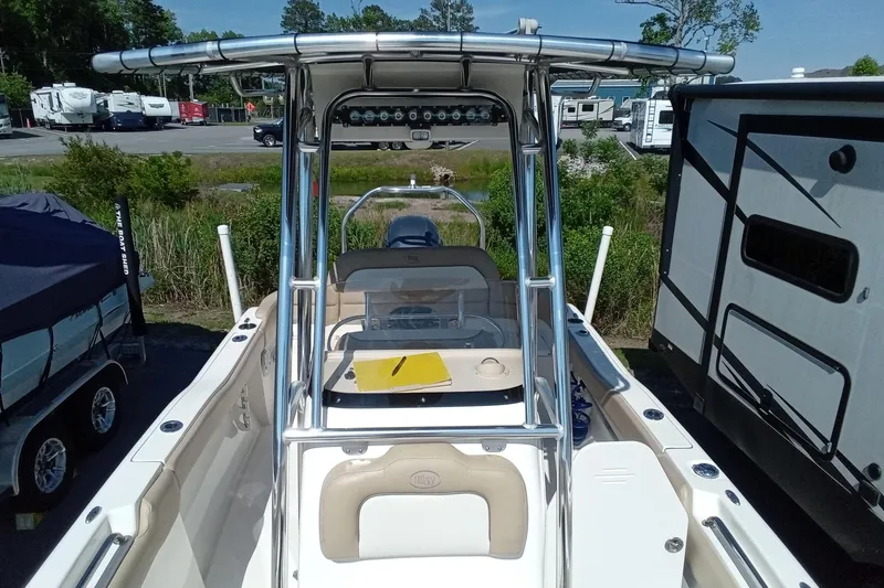 Slide: The Image of 2015 Key West 203 FS boat with T-top, parked near RVs and greenery. - 12