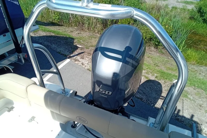 Slide: The Image of 2015 Key West 203 FS boat with Yamaha 150 engine, parked near greenery. - 24