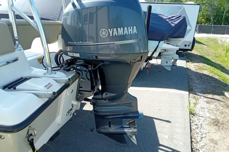 Slide: The Image of 2015 Key West 203 FS boat with Yamaha four-stroke outboard motor, parked outdoors. - 27