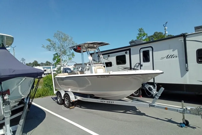 Slide: The Image of 2015 Key West 203 FS boat on trailer, parked near RVs under clear blue sky. - 37