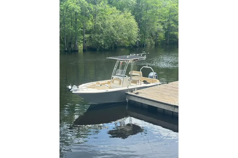 Slide: The Image of 2015 Key West 203 FS boat docked on a serene lake with lush greenery. - 5