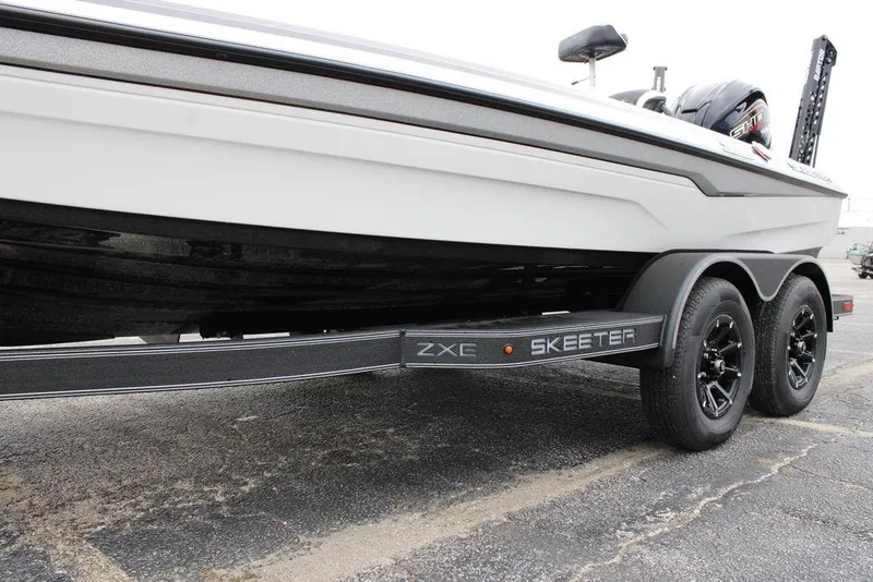 Slide: The Image of 2026 Skeeter ZXE21 boat on trailer, showcasing sleek design and dual-axle wheels. - 15