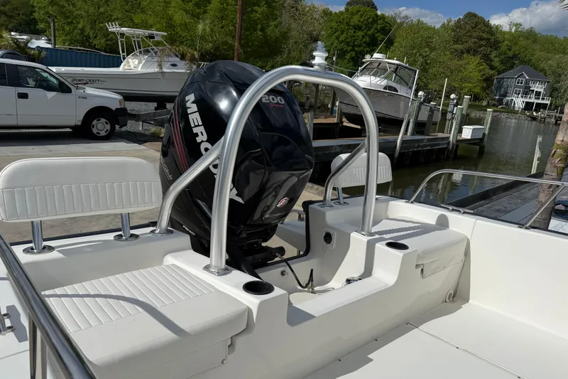 Slide: The Image of 2018 Boston Whaler 210 Montauk boat with Mercury engine, docked near waterfront homes. - 15