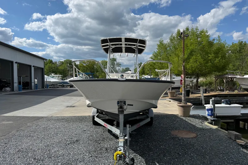 Slide: The Image of 2018 Boston Whaler 210 Montauk boat on trailer at marina under cloudy sky. - 2