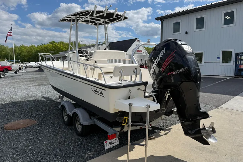 Slide: The Image of 2018 Boston Whaler 210 Montauk boat with Mercury engine on trailer, parked outdoors. - 3