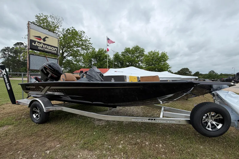 The Image of 2026 Xpress H18C Crappie boat on trailer at Johnson Outdoors dealership. - 0
