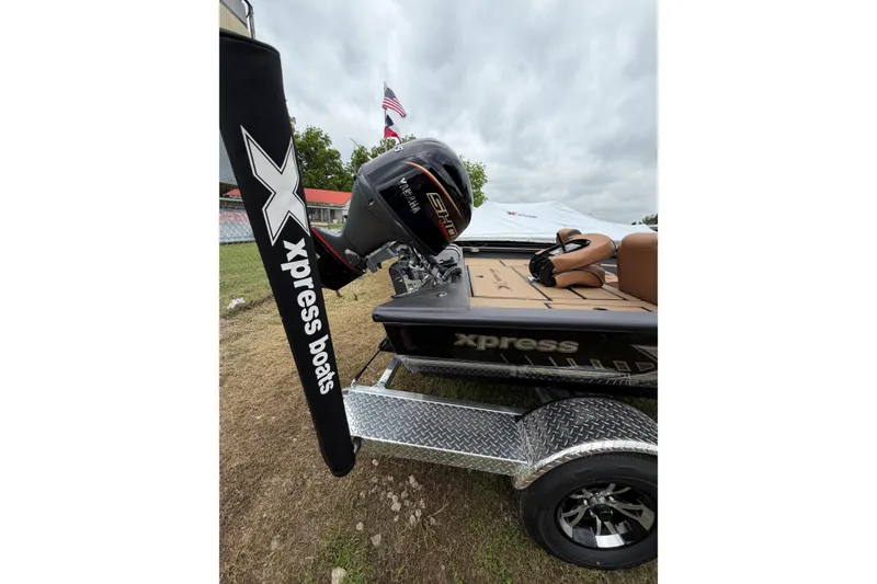 Slide: The Image of 2026 Xpress H18C Crappie boat on trailer, featuring powerful outboard motor. - 3