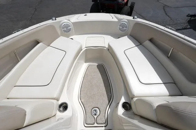 Slide: The Image of 2010 Sea Ray 220 Sundeck boat interior with white seating and deck. - 10