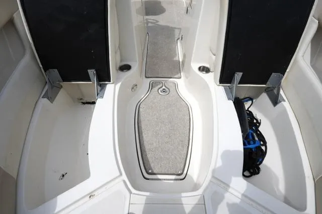 Slide: The Image of 2010 Sea Ray 220 Sundeck interior with open storage compartments and carpeted flooring. - 11