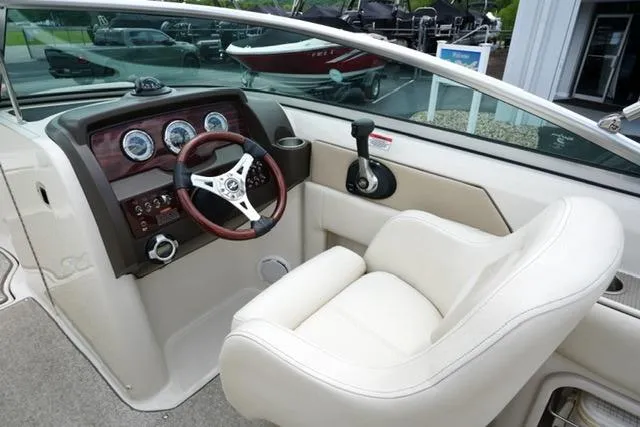 Slide: The Image of Interior view of 2010 Sea Ray 220 Sundeck boat cockpit with steering wheel and gauges. - 13