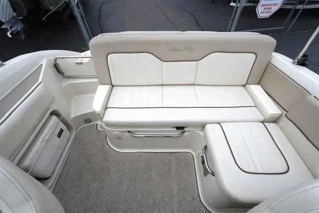 Slide: The Image of 2010 Sea Ray 220 Sundeck interior with white cushioned seating and carpeted flooring. - 16