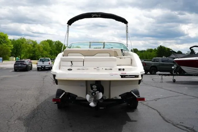 Slide: The Image of 2010 Sea Ray 220 Sundeck boat parked on asphalt under cloudy sky. - 6