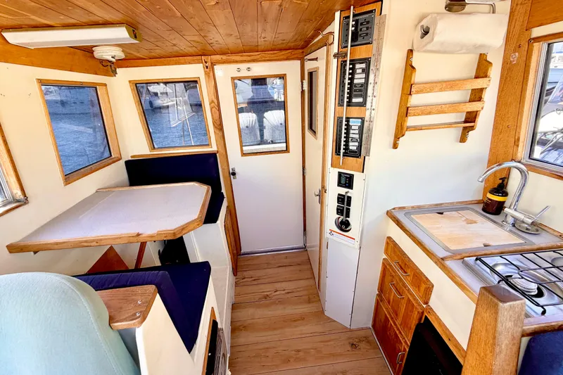 Slide: The Image of 1970 Bertram boat interior with wooden accents, kitchenette, and seating area. - 10