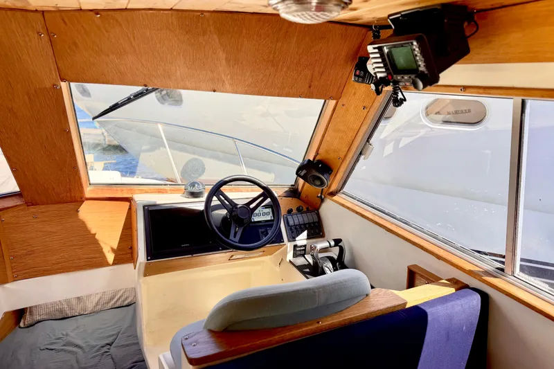 Slide: The Image of Interior of a 1970 Bertram boat with wooden dashboard and steering wheel. - 12