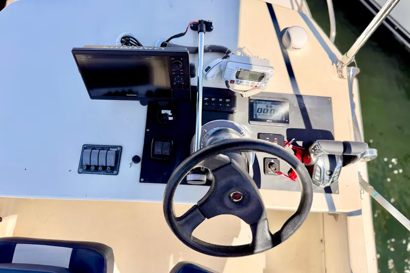 Slide: The Image of 1970 Bertram boat dashboard with steering wheel, controls, and navigation equipment. - 19