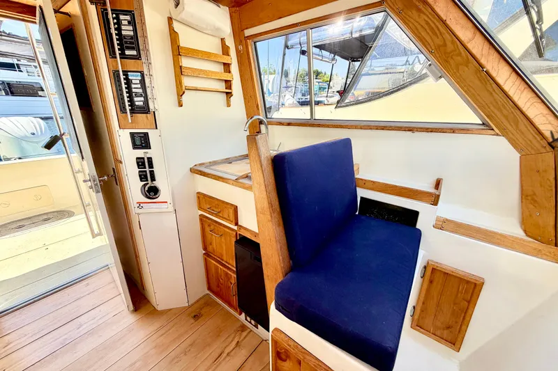 Slide: The Image of 1970 Bertram boat interior with blue seating, wooden accents, and control panel. - 7