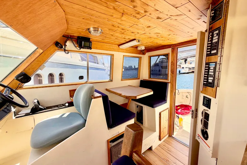 Slide: The Image of Interior of a 1970 Bertram boat with wooden paneling and seating area. - 8