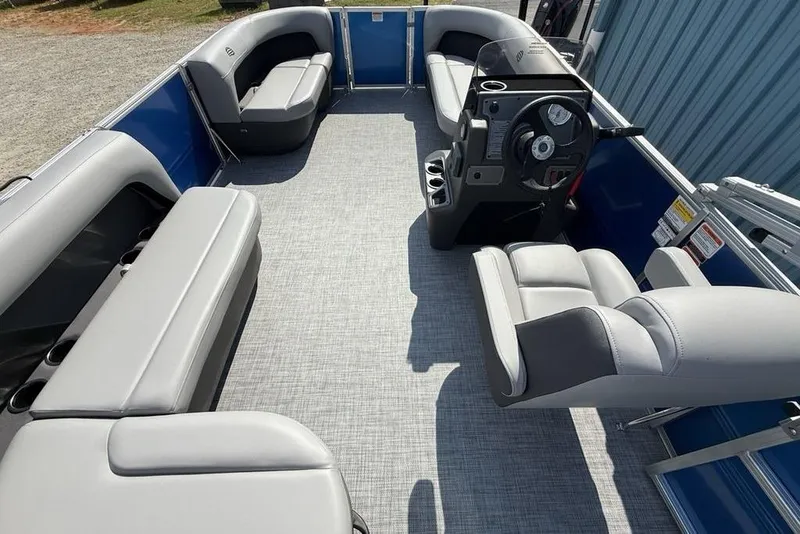 Slide: The Image of 2026 Sun Tracker Party Barge 16 DLX interior with gray seating and steering console. - 12