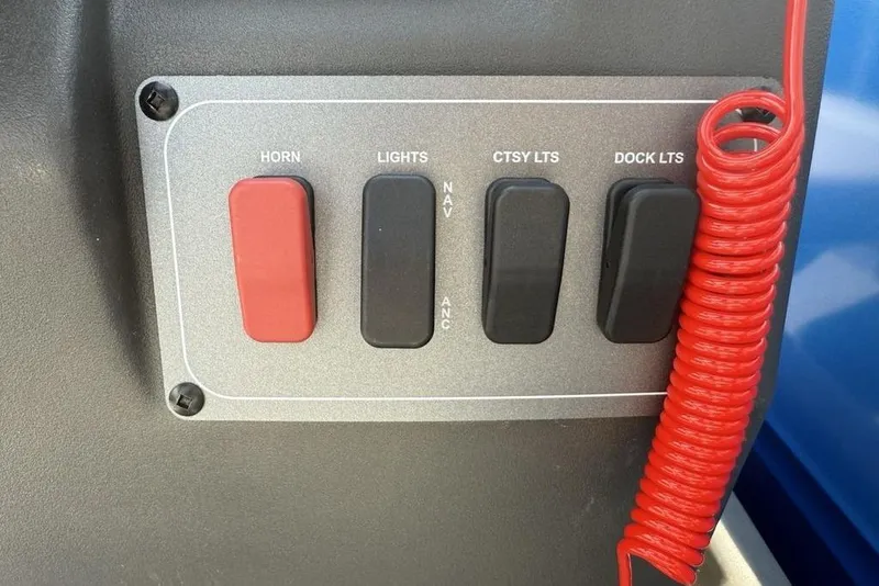 Slide: The Image of Control panel of 2026 Sun Tracker Party Barge 16 DLX with switches and coiled red cord. - 14