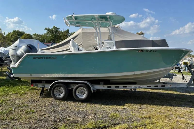 The Image of 2023 Sportsman Heritage 231 Center Console boat on trailer, parked outdoors. - 1