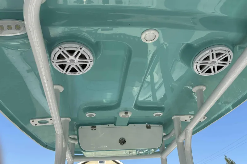 Slide: The Image of 2023 Sportsman Heritage 231 Center Console boat with teal ceiling and built-in speakers. - 3