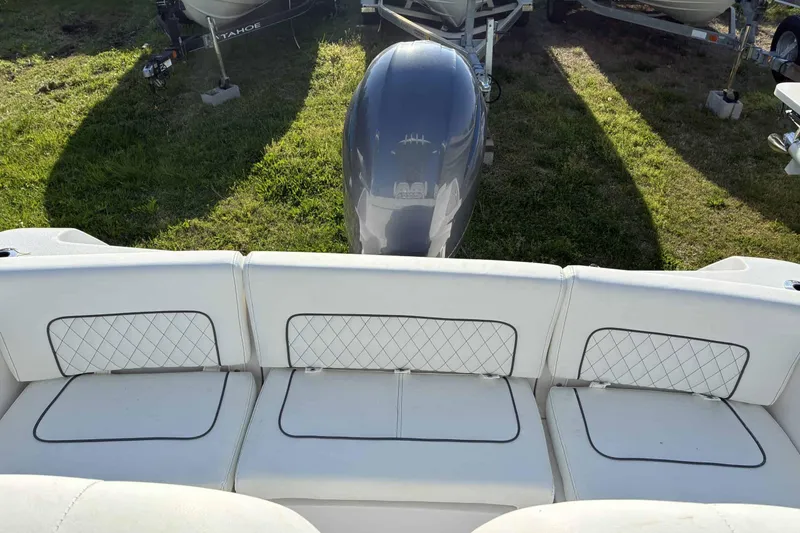 Slide: The Image of 2023 Sportsman Heritage 231 Center Console boat with cushioned seating and outboard motor. - 7