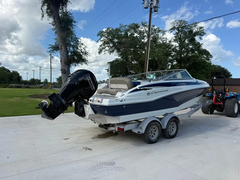 Slide: The Image of 2022 Crownline Eclipse E215 XS boat on trailer, parked outdoors under a blue sky. - 5