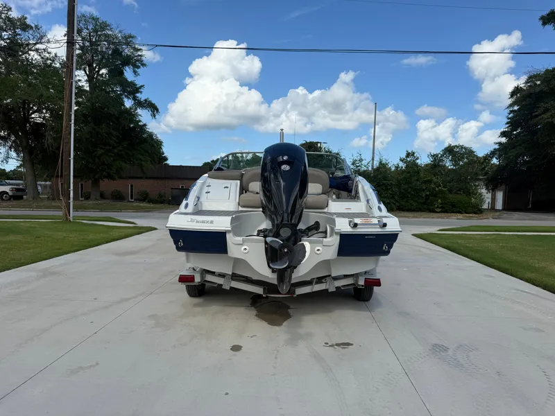 Slide: The Image of 2022 Crownline Eclipse E215 XS boat with outboard motor on driveway. - 6