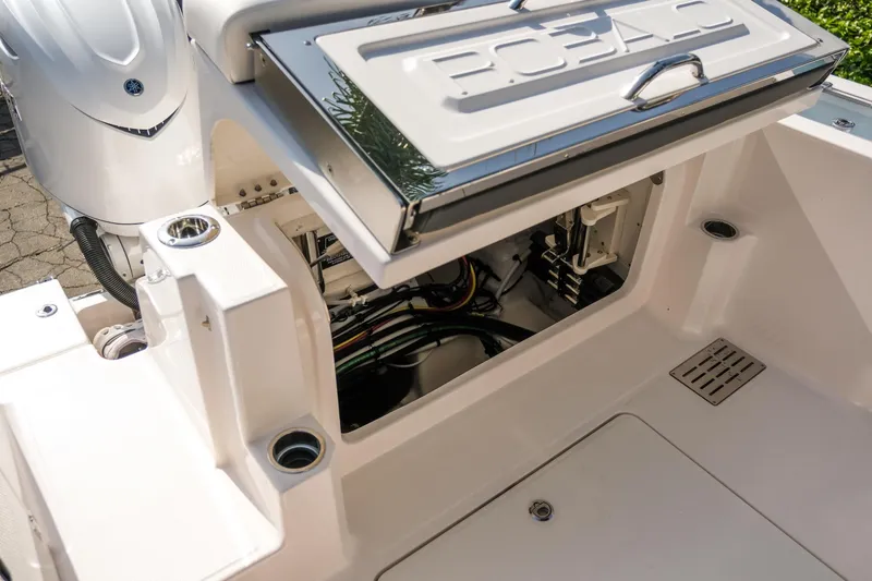 Slide: The Image of 2025 Robalo R300 Center Console boat with open storage compartment and visible wiring. - 16