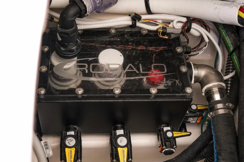 Slide: The Image of Engine compartment of 2025 Robalo R300 Center Console with visible wiring and components. - 21