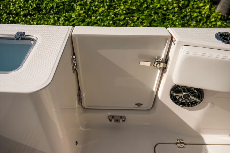 Slide: The Image of 2025 Robalo R300 Center Console boat interior with storage compartment and speaker. - 23